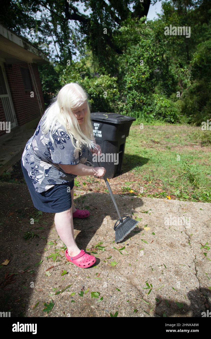 Frau, die einen Hof putzen soll Stockfoto