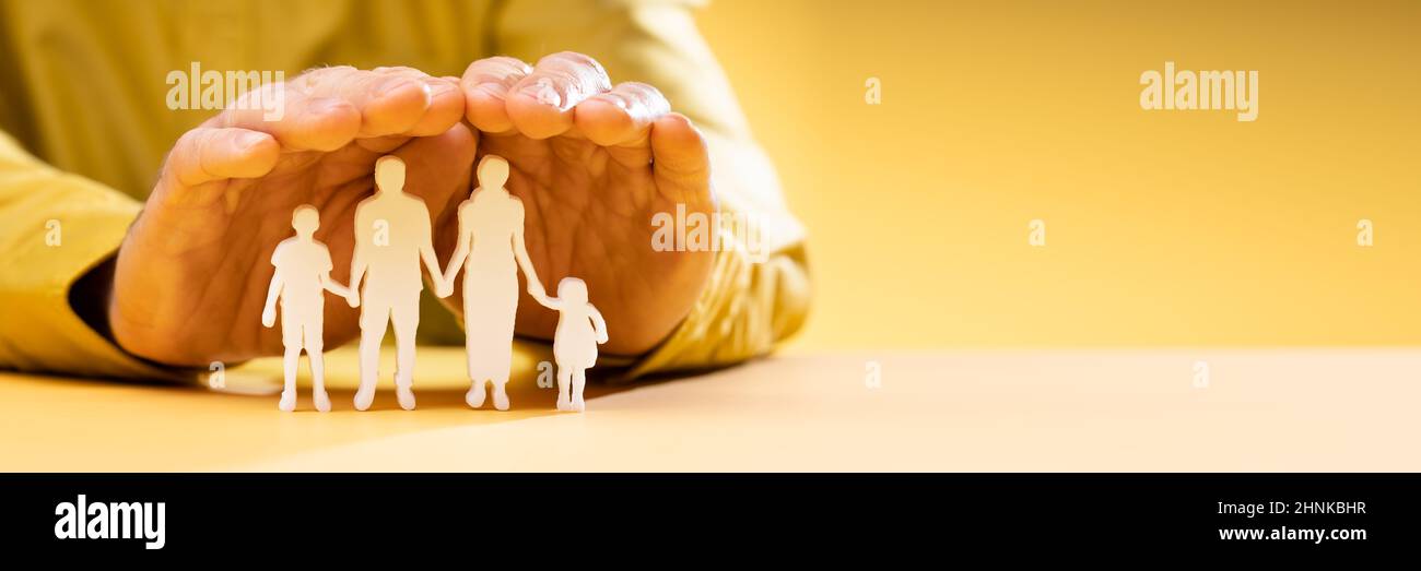 Die Hand des Geschäftsreisenden schützt die Familie Figur ausgeschnitten Stockfoto