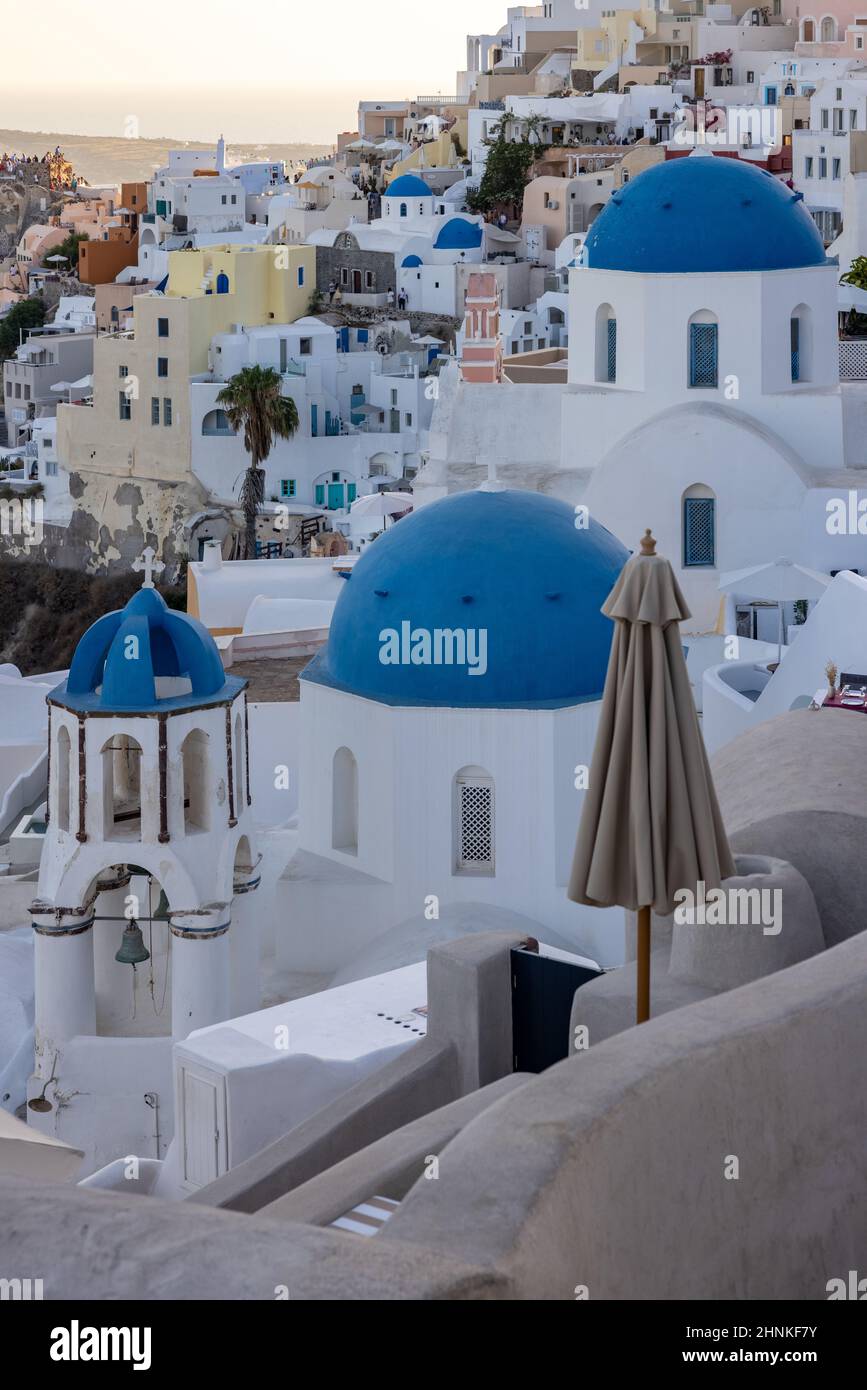Blick vom Aussichtspunkt auf das Dorf Oia mit blauen Kuppeln griechisch-orthodoxer christlicher Kirchen und traditioneller, weiß getünchtes griechisches Architektur. Santorini, Griechenland Stockfoto