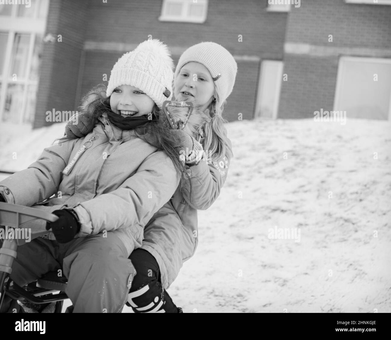 Zwei junge Mädchen Rodeln zusammen und lächeln Stockfoto