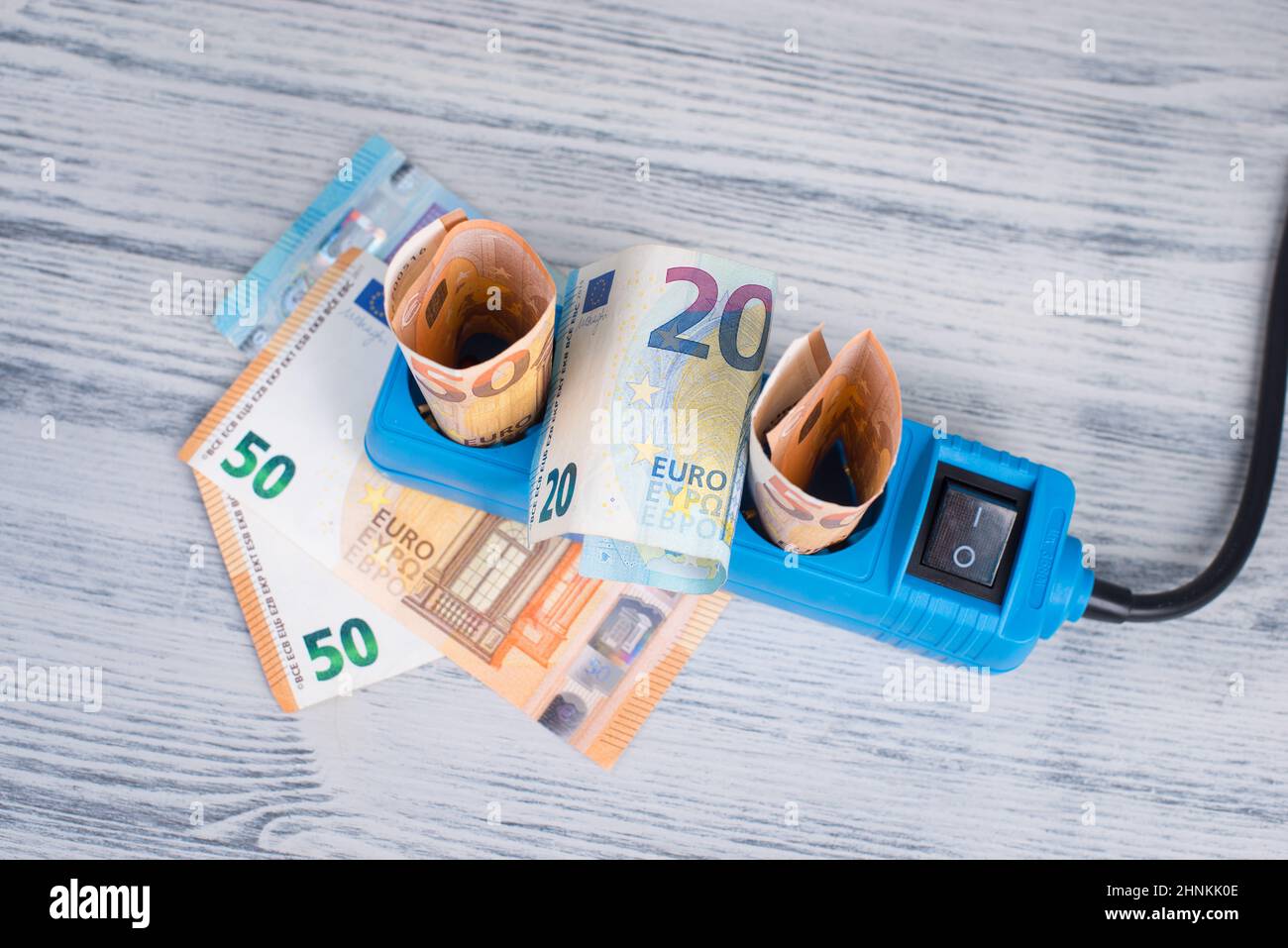 Euro-Banknoten in einer Steckdose, steigende Preise, teurer Ökostrom, Deutschland Stockfoto