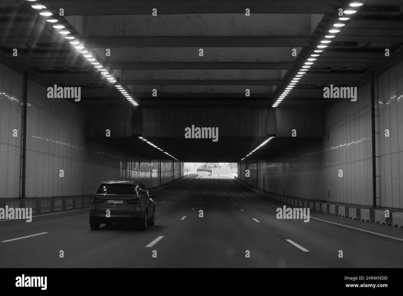 Auto fährt schwarz und weiß durch den Tunnel Stockfoto