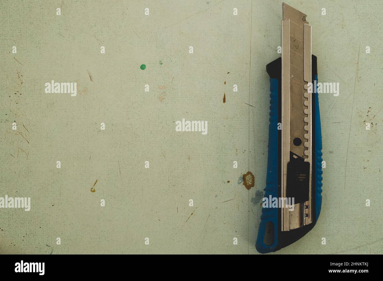 Schreibwarenmesser auf dem Holzboden. Schneidemesser auf der Arbeitsfläche Stockfoto