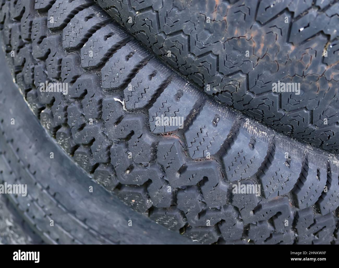 Beschädigte und abgenutzte alte schwarze Reifen auf einem Stapel. Beschädigte und abgenutzte alte schwarze Reifen auf einem Stapel. Probleme mit der Reifenlauffläche. Lösungskonzept. Probleme mit der Reifenlauffläche. Stockfoto