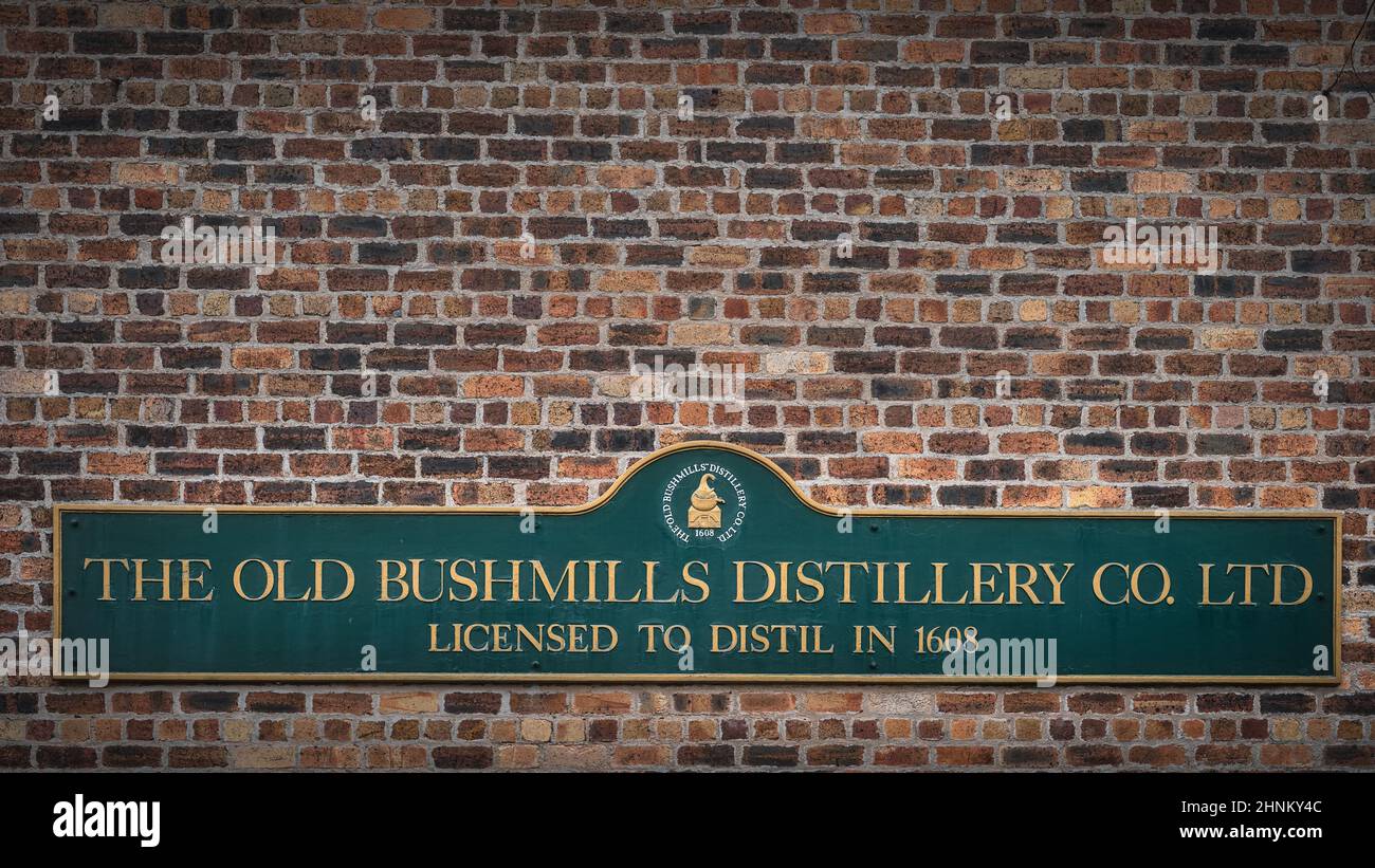 Die Old Bushmills Distillery Co. Ltd lizenziert zu destillieren in 1608 Zeichen auf rustikalen Backsteinmauer Stockfoto