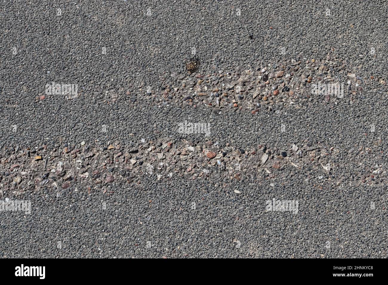 Detailansicht auf Asphaltflächen verschiedener Straßen und Straßen mit Rissen aus nächster Nähe Stockfoto