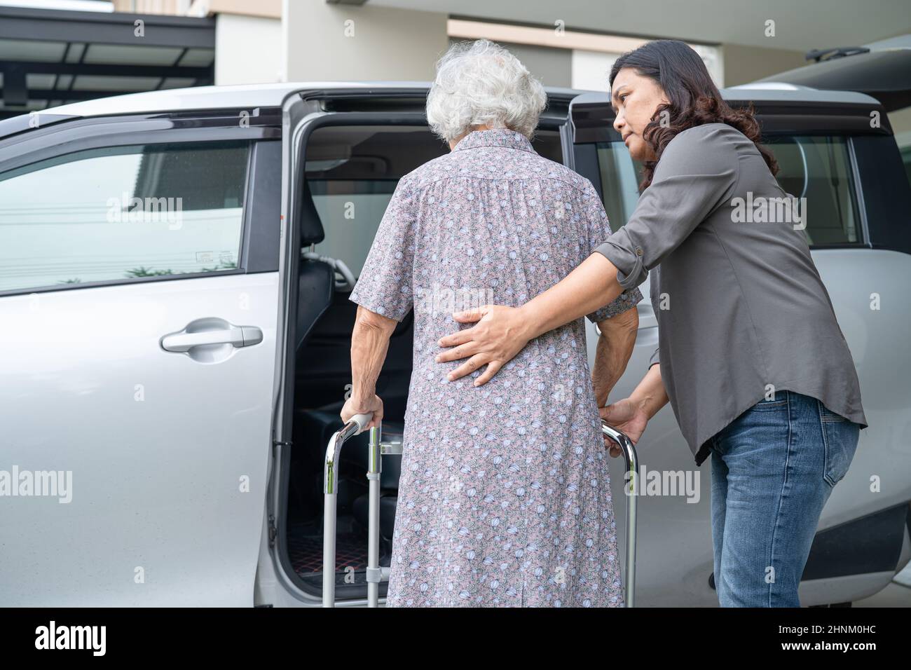 Hilfe und Unterstützung asiatische ältere oder ältere alte Dame Frau Patientin gehen mit Wanderer Vorbereitung zu ihrem Auto, gesund starke medizinische Konzept. Stockfoto