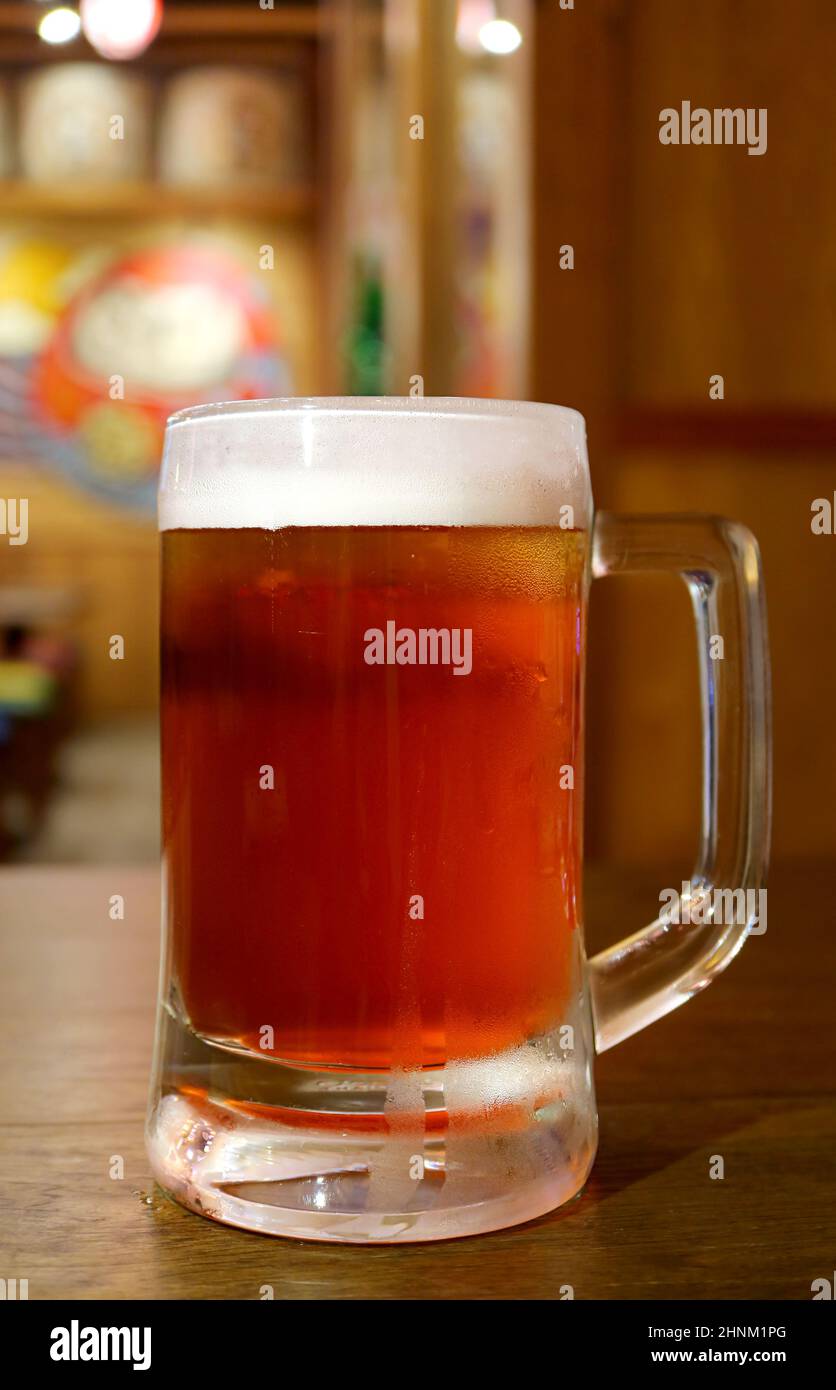 Nahaufnahme ein Becher gekühltes Bier, das auf einem Holztisch serviert wird Stockfoto