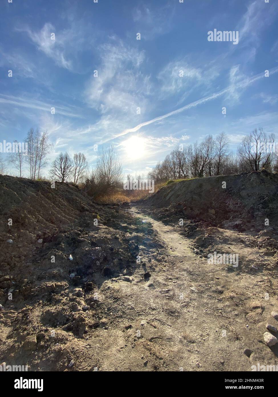 Vertikale Aufnahme einer unbefestigten Straße in der Landschaft bei Sonnenaufgang Stockfoto