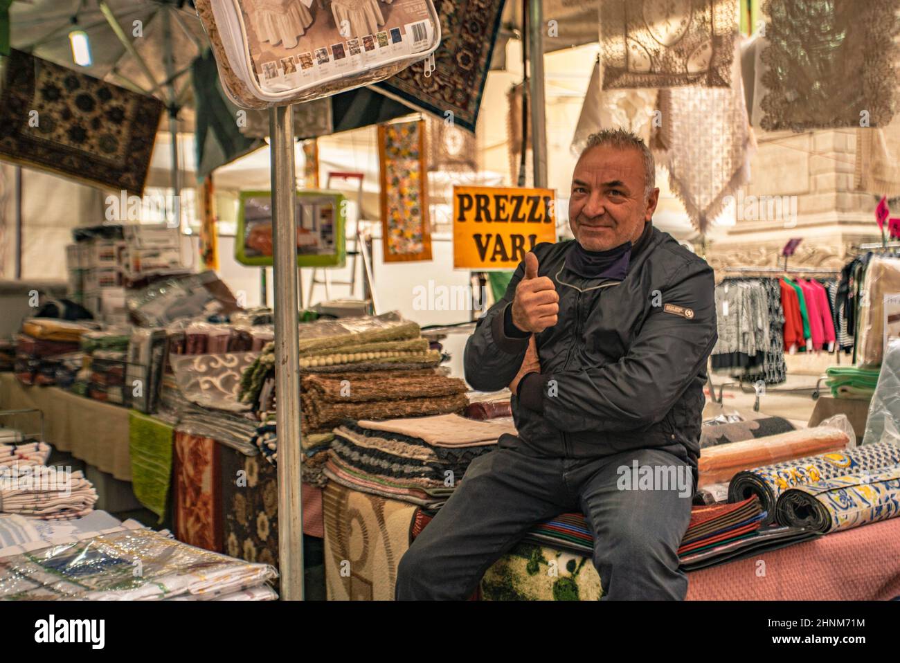 Mann verkauft Teppiche am Marktstand Stockfoto