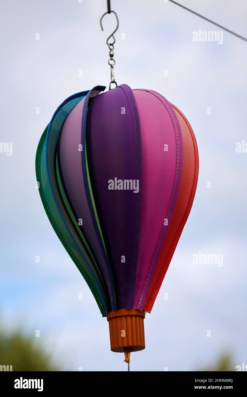 Ein Windspiel in Form eines Ballons hängt an einer Linie und dreht sich im Wind. Stockfoto