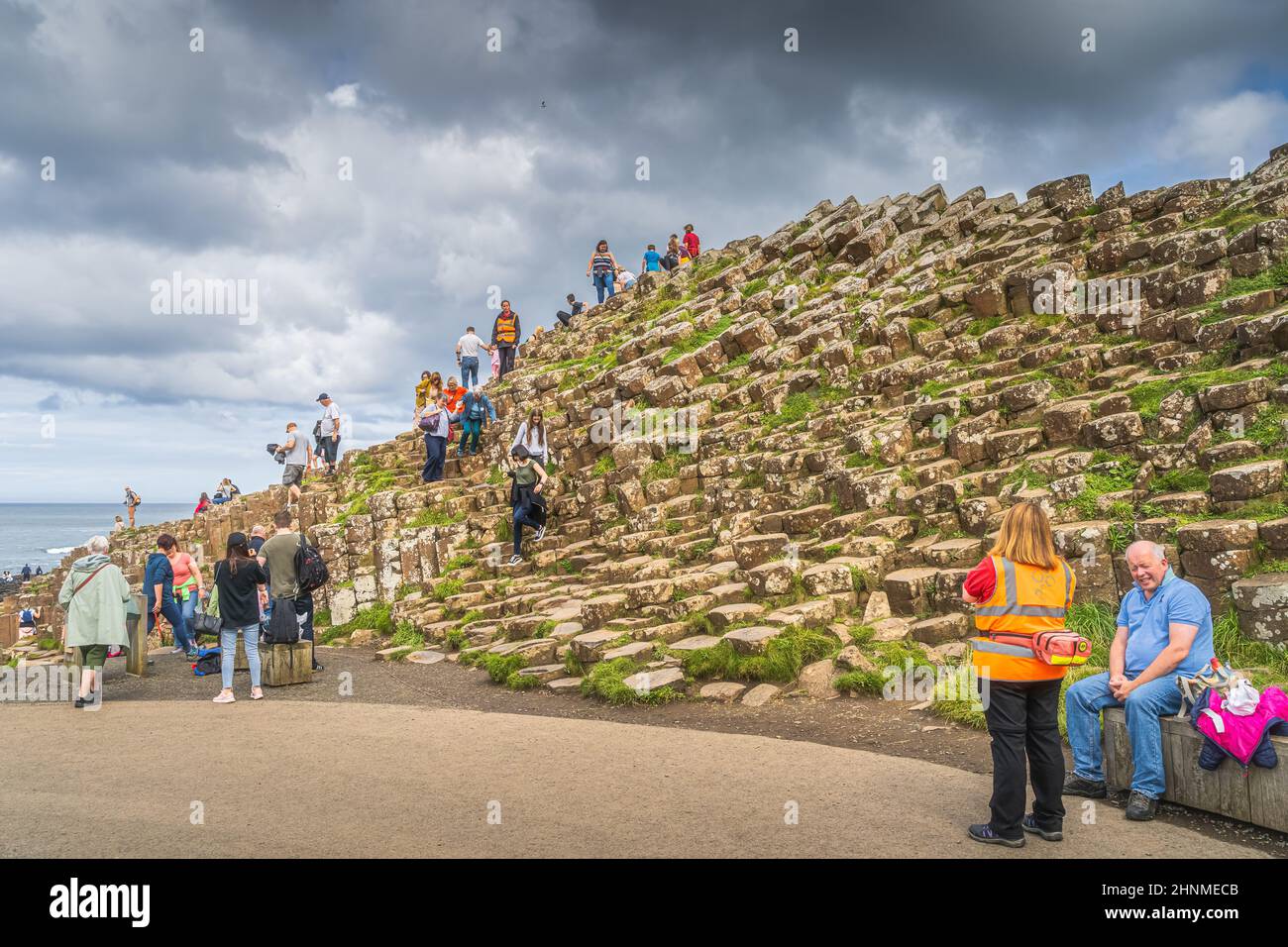 Touristen bewundern die sechseckige Felsformation in Giants Causeway, UNESCO-Weltkulturerbe Stockfoto