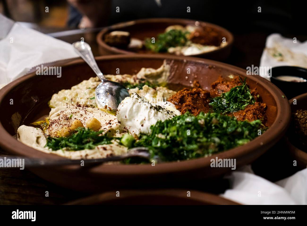 Verschiedene Gerichte aus dem Nahen Osten, darunter Hummus, baba Ghanoush, Tabbouleh und Salat. Orientalische Vorspeise auf rostigen Tellern Stockfoto