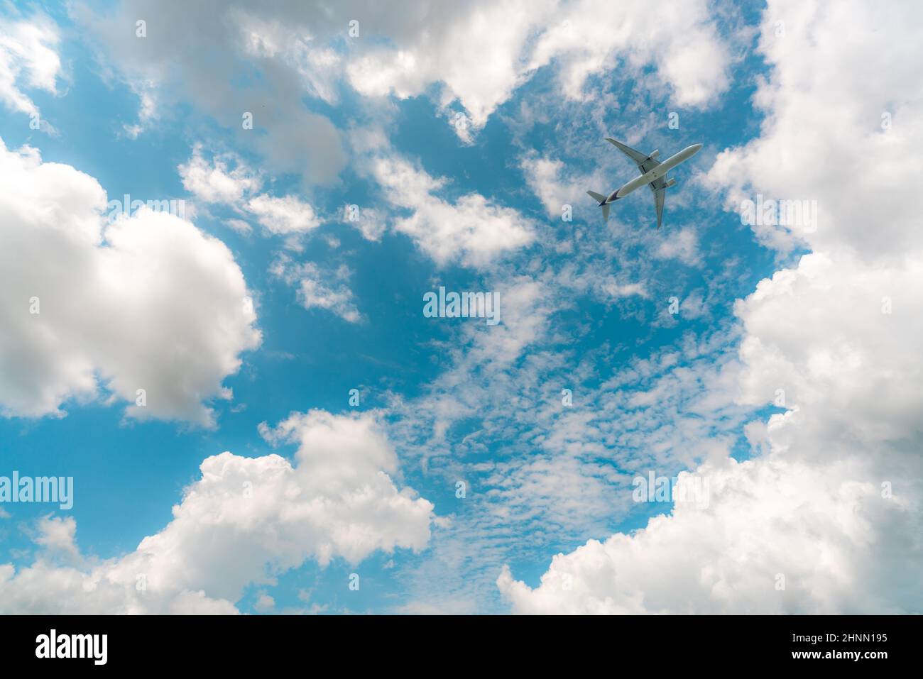 Kommerzielle Fluggesellschaft, die auf blauen Himmel und weißen Cumulus-Wolken fliegt. Unter Ansicht Flugzeug fliegen. Passagierflugzeug Reise Luftblasenflug. Urlaubsreisen ins Ausland nach der Coronavirus-Krise. Lufttransport. Stockfoto