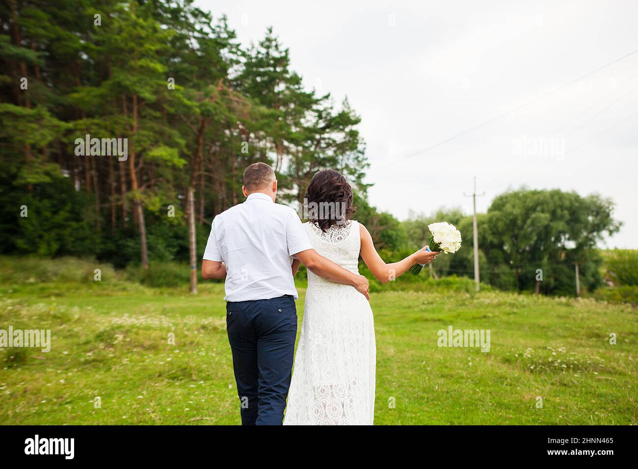 Braut und Bräutigam gehen in den Wald Stockfoto