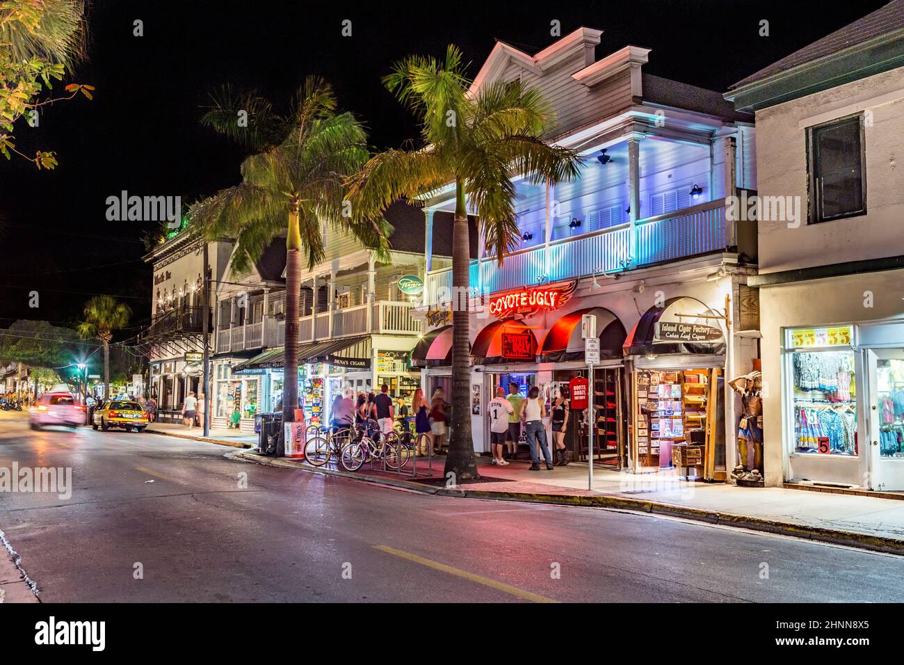 Die Leute laufen entlang der Hauptstraße in Key West mit Geschäften in der Nacht. Die malerische Hauptstraße ist das touristische Haupteinkaufsviertel für Touristen. Stockfoto