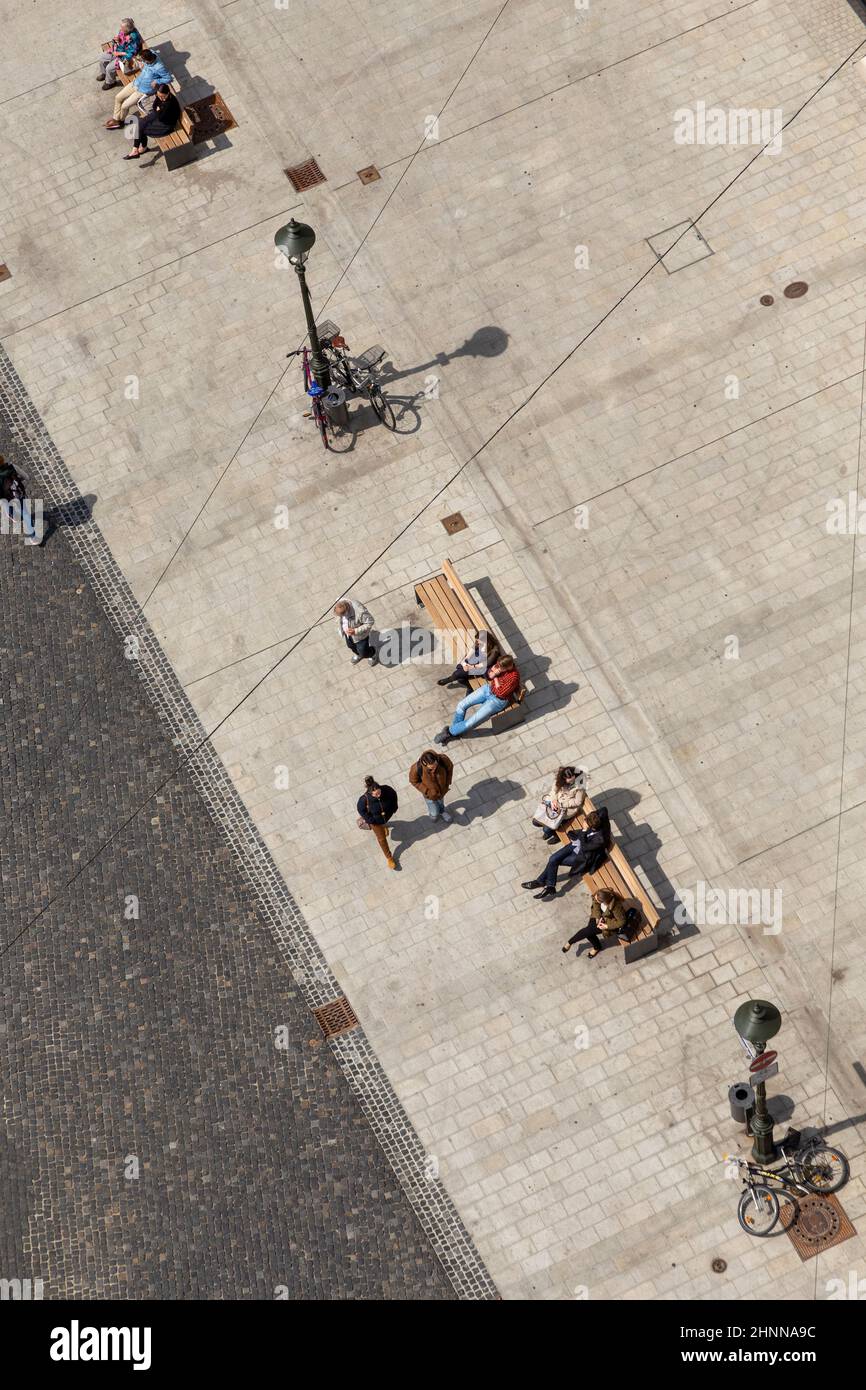 Am historischen Marktplatz an einer Bank mit Blick auf Fachwerkhäuser in Augsburg haben die Menschen viel Spaß Stockfoto