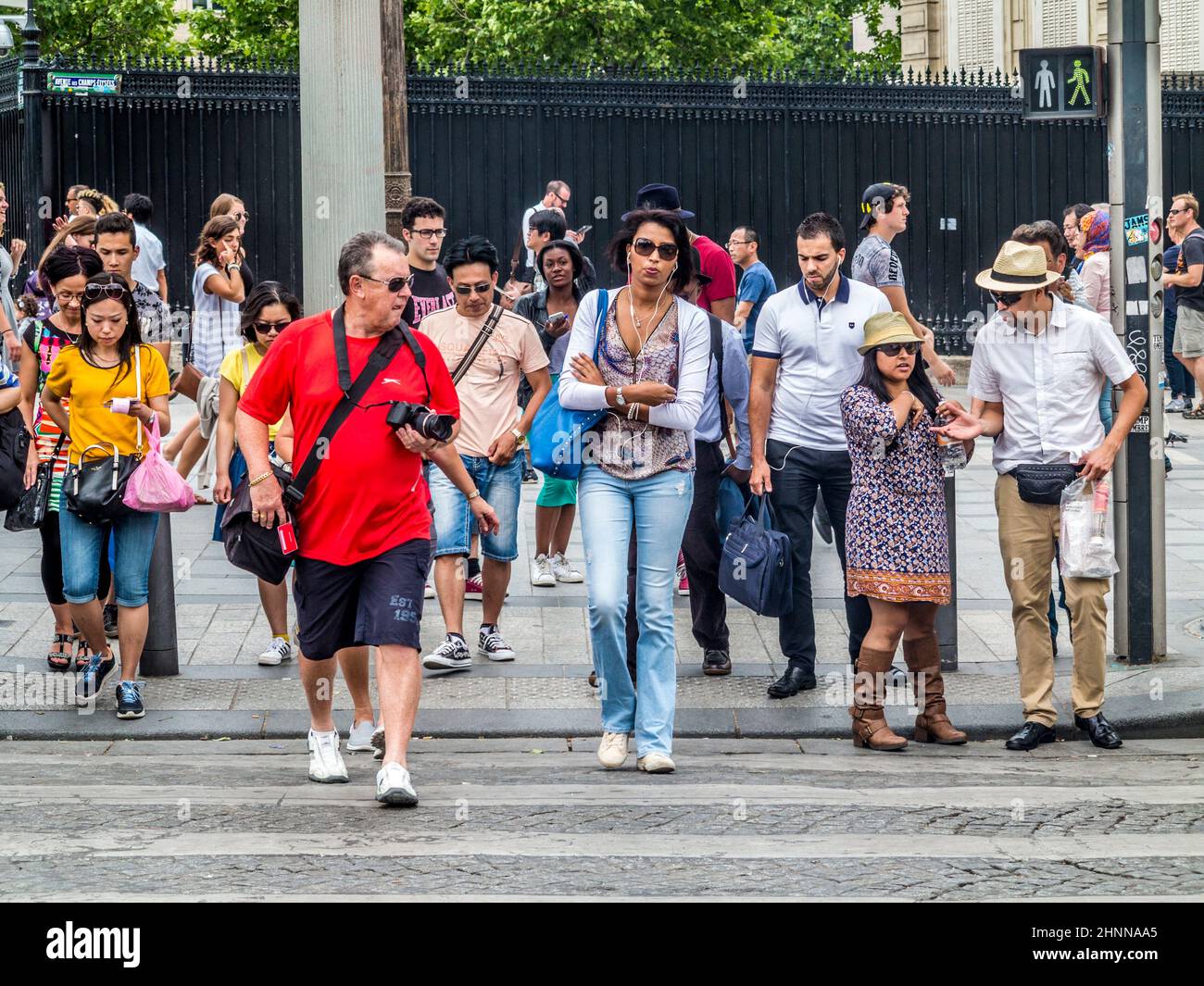 An einer Kreuzung im Herzen von Paris überqueren die Menschen die Straße an einer Straßenampel für Fußgänger Stockfoto