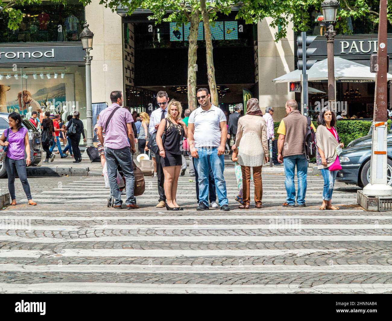 An einer Kreuzung im Herzen von Paris überqueren die Menschen die Straße an einer Straßenampel für Fußgänger.an der Champs d´ Elysees Stockfoto