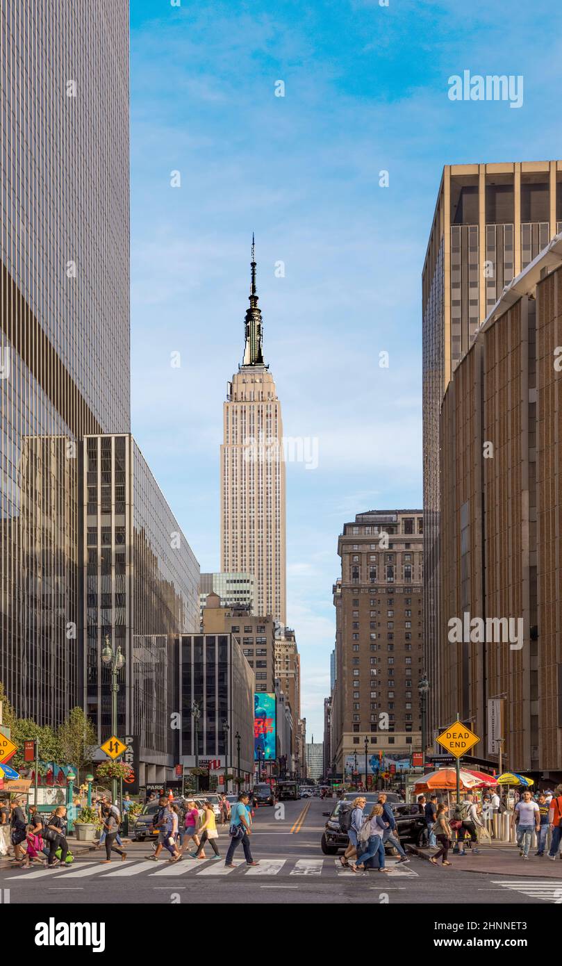 Blick auf die Innenstadt von Manhattan, New York mit Chrysler-Gebäude im Hintergrund und Menschen, die eine Straße überqueren Stockfoto