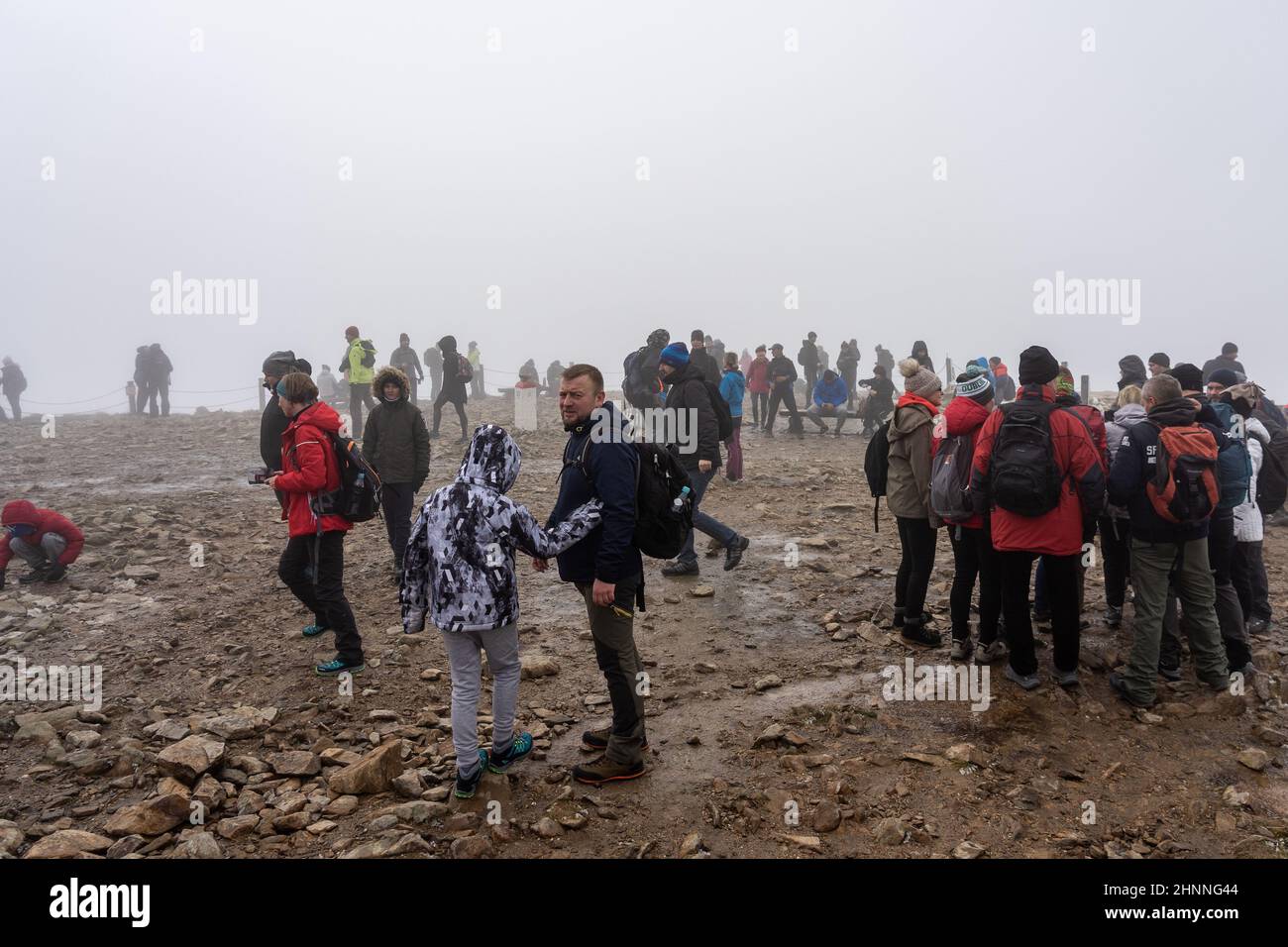 KARPACZ, POLEN - 16. OKTOBER 2021: Touristen auf dem Gipfel von Sniezka im Riesengebirge bei bewölktem Wetter. Stockfoto