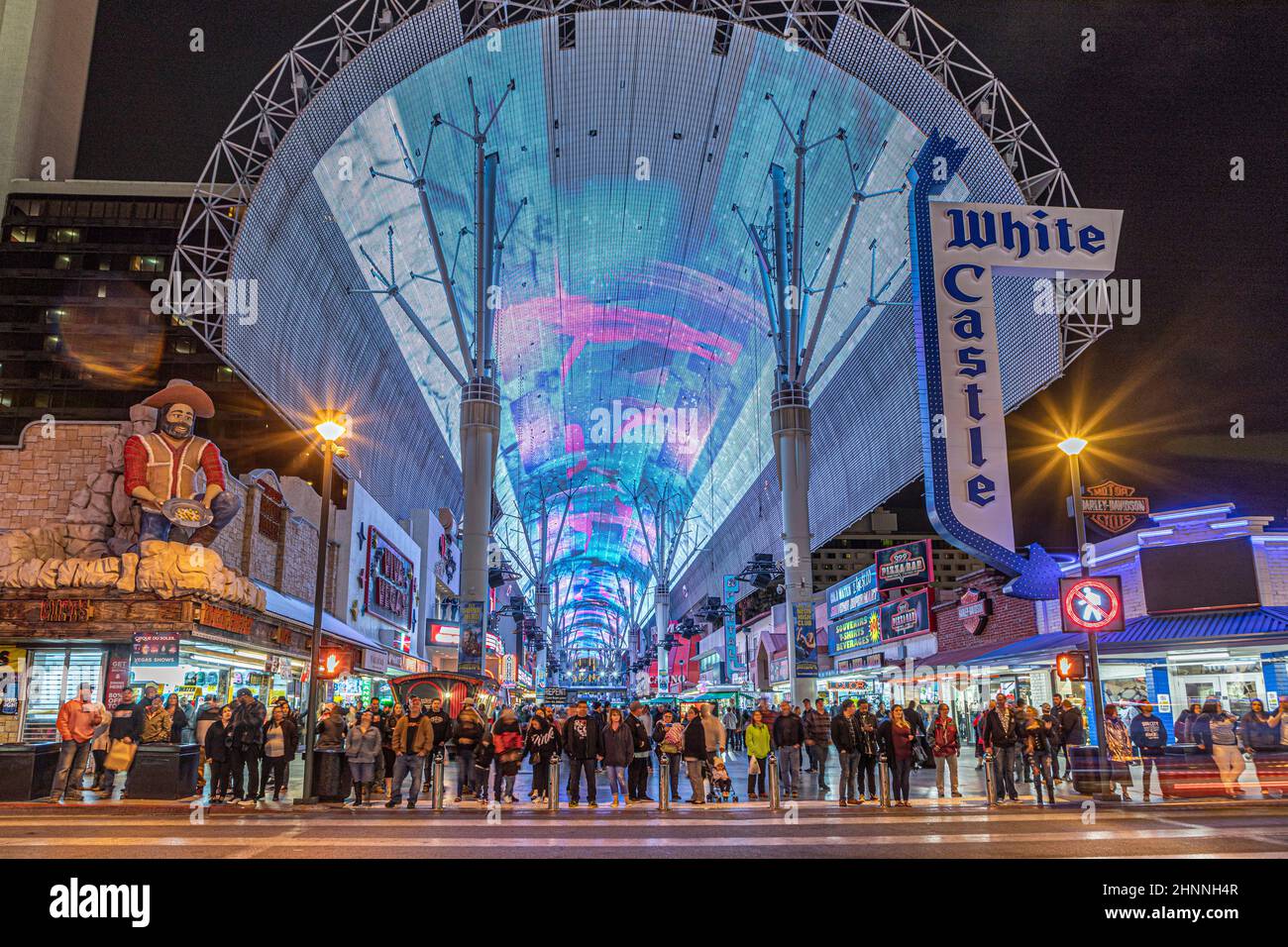 Menschen, die die Straße bei beleuchteten Casinos in der Fremont Street in Las Vegas bei Nacht überqueren. Die Fremont Street war der erste Platz für Casinos in Las Vegas Stockfoto