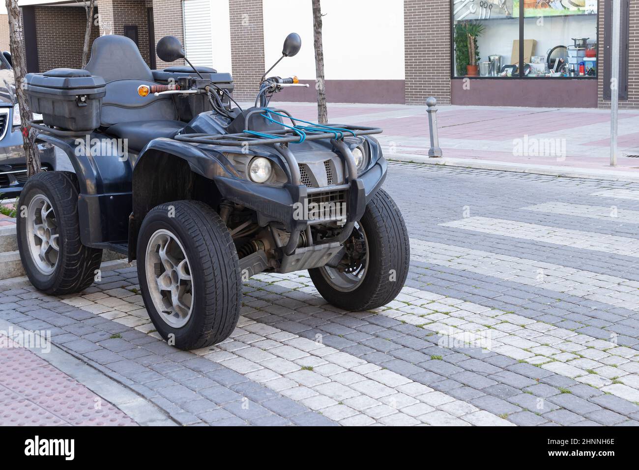 Schwarz Farbe ATV Quad-Fahrrad auf der Straße über dem Fußgängerüberweg geparkt.andere Formen der städtischen Mobilität Stockfoto
