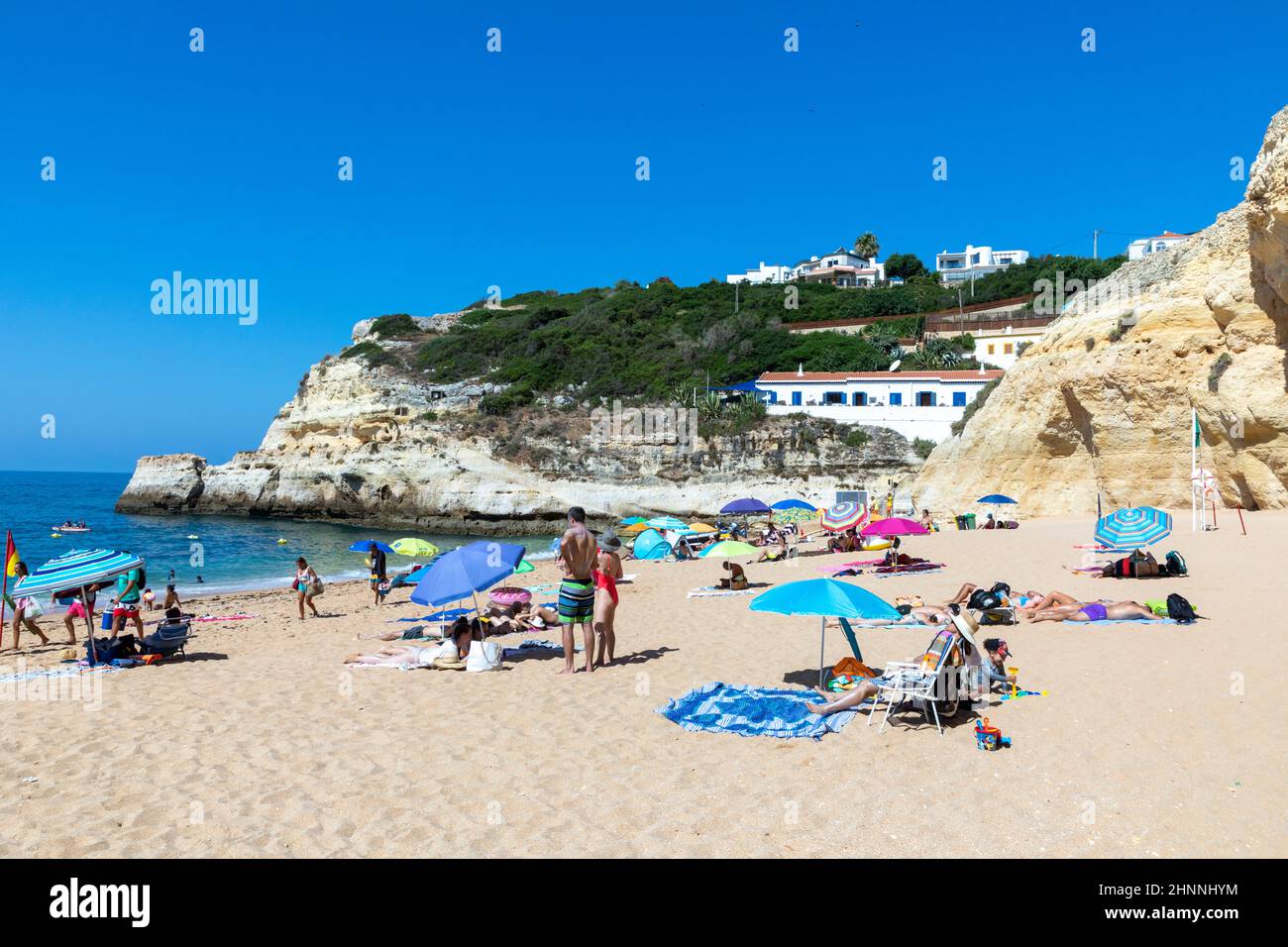 Die Menschen genießen den malerischen Strand an der Algarve-Küste in der Nähe von Carvoeiro und befolgen die Regeln für Touristen am Strand nach den Corona-Regeln Stockfoto
