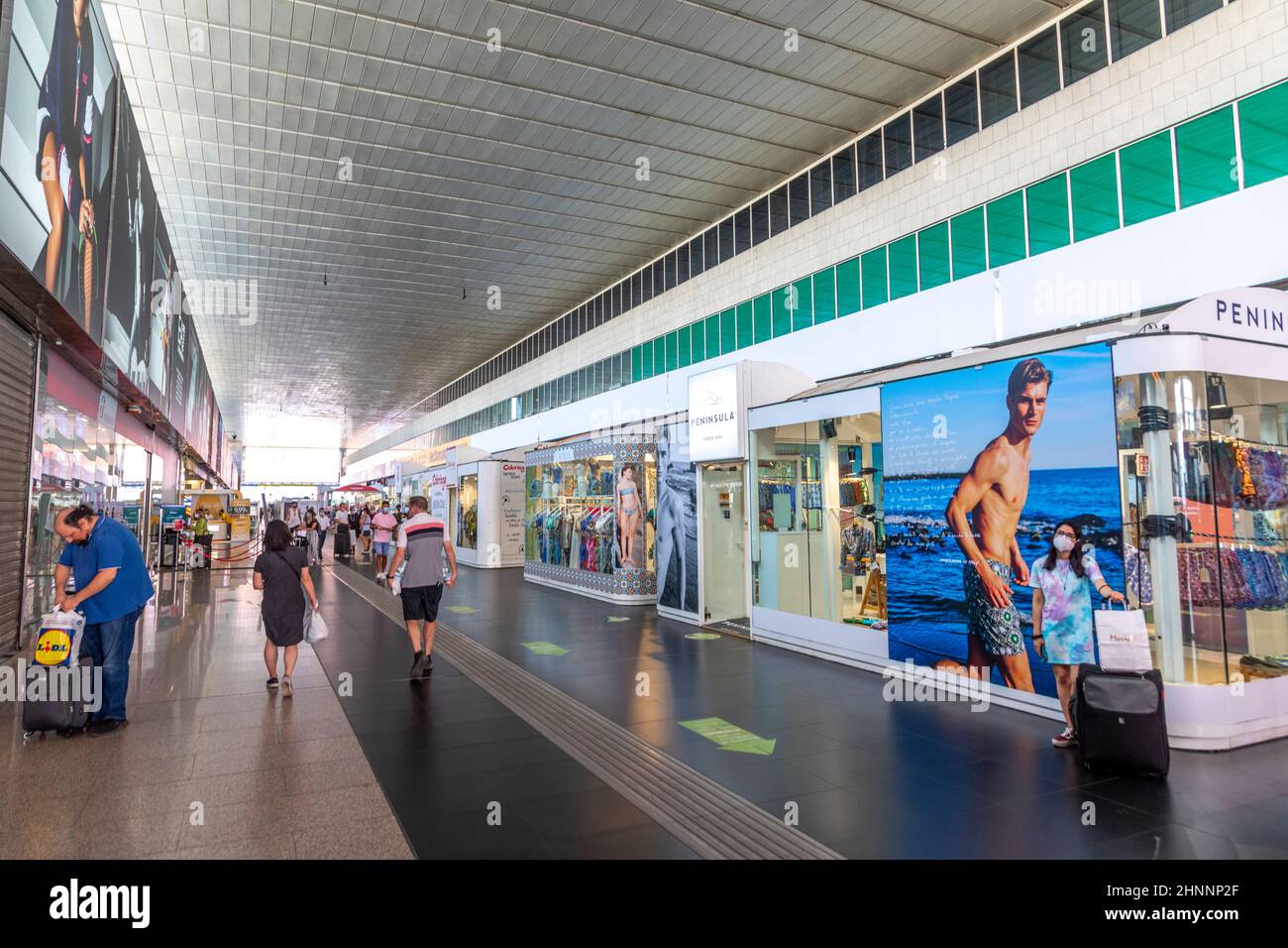 Die Menschen im Bahnhof Roma Termini sind auf dem Weg zum Zug. Der Bahnhof beherbergt Geschäfte für Essen und moderne Kleidung. Stockfoto