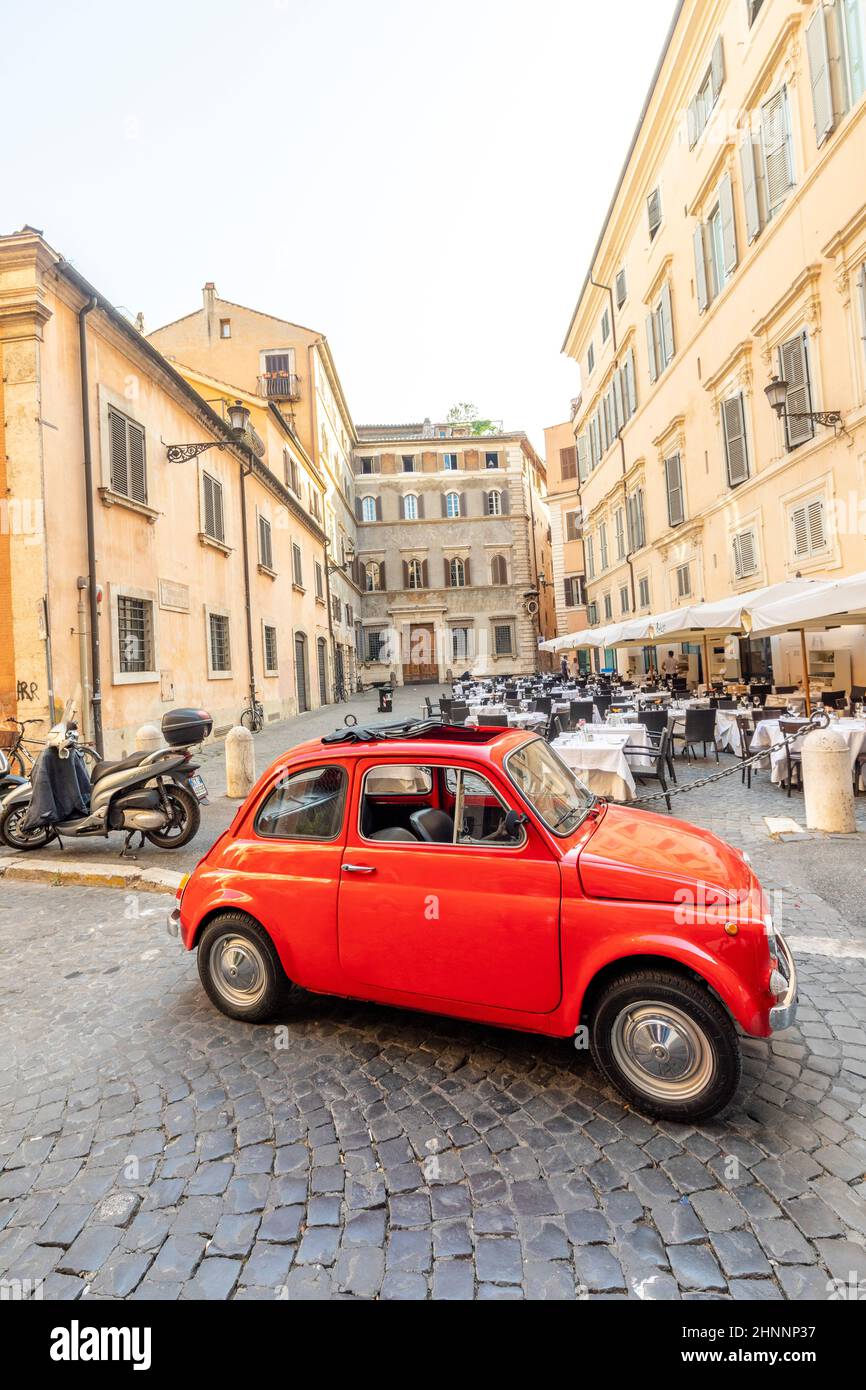 Der alte Fiat 500 parkte neben einem Restaurant in Rom in der Innenstadt im Viertel Regla in der Kopfsteinpflasterstraße. Die weltberühmte italienische Automobilmarke wurde 1899 gegründet. Stockfoto