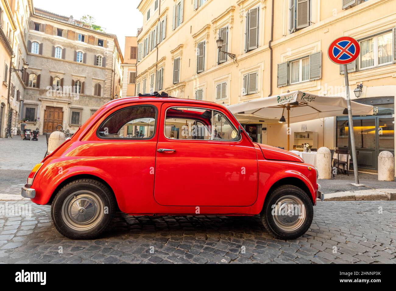 Der alte Fiat 500 parkte neben einem Restaurant in Rom in der Innenstadt im Viertel Regla in der Kopfsteinpflasterstraße. Die weltberühmte italienische Automobilmarke wurde 1899 gegründet. Stockfoto