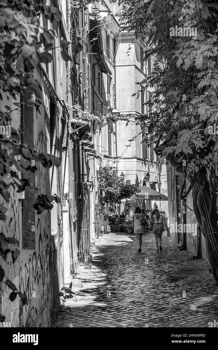 Die Menschen genießen die Restaurants in den kleinen Straßen im Viertel Trastevere in Rom, Italien Stockfoto