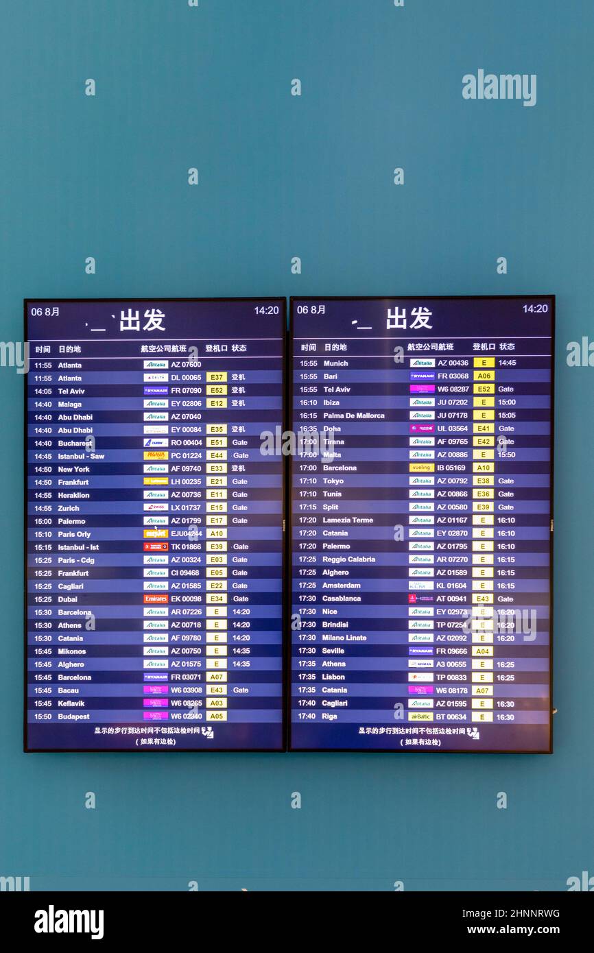 Ankunfts- und Abfahrtszeiten an einer Schildertafel am römischen Flughafen Fiumicino in chinesischer Mandarin-Sprache Stockfoto