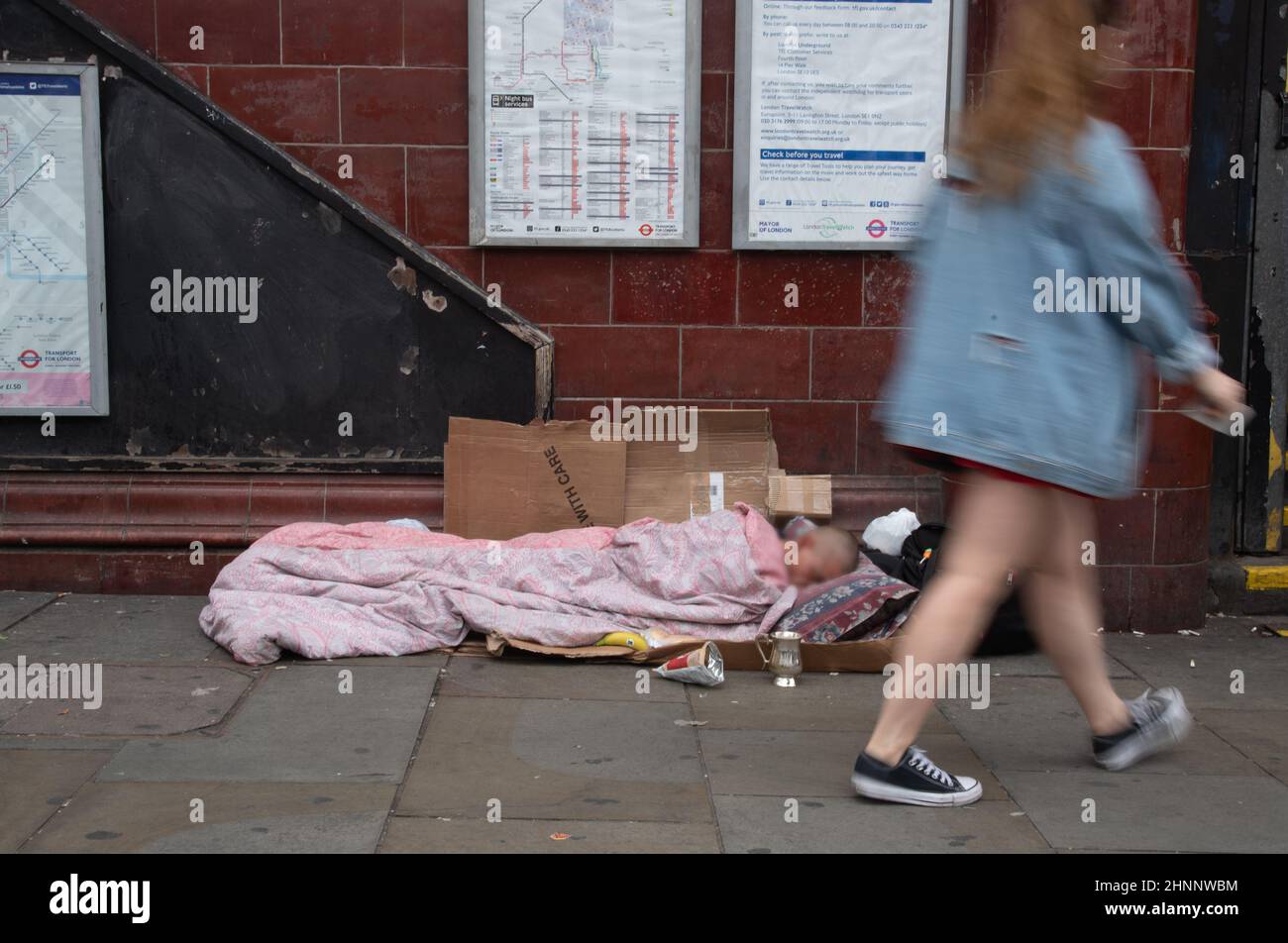 Unerkannte Obdachlose, die vor einer U-Bahn-Station auf der Straße schlafen Stockfoto