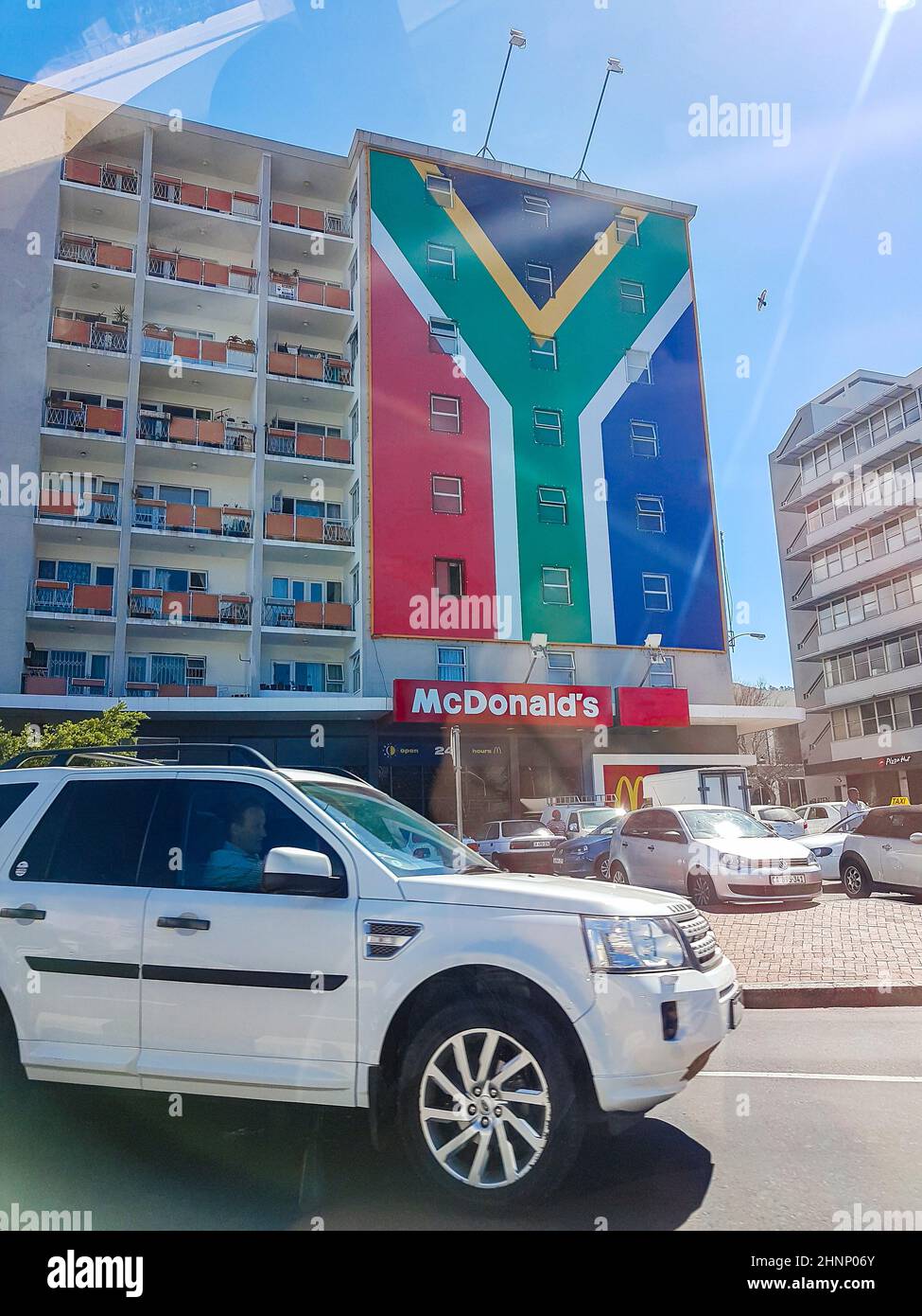 Gebäude Wolkenkratzer, Wohnblock mit riesiger südafrikanischer Flagge. Stockfoto