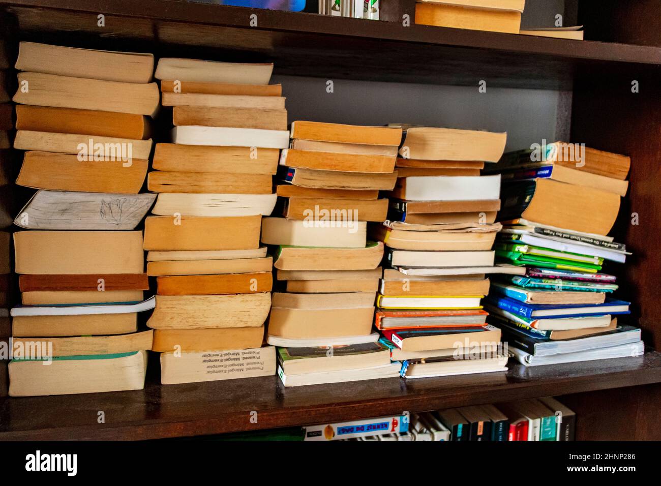 Alte vergilbte Bücher im Regal in Bücherregal, Bibliothek gestapelt. Stockfoto