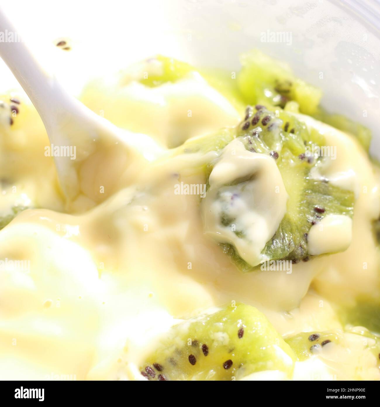 Food and Drink Concept – Nahaufnahme von geschnittenem Kiwi-Obst und cremigem Custard-Dessert Stockfoto