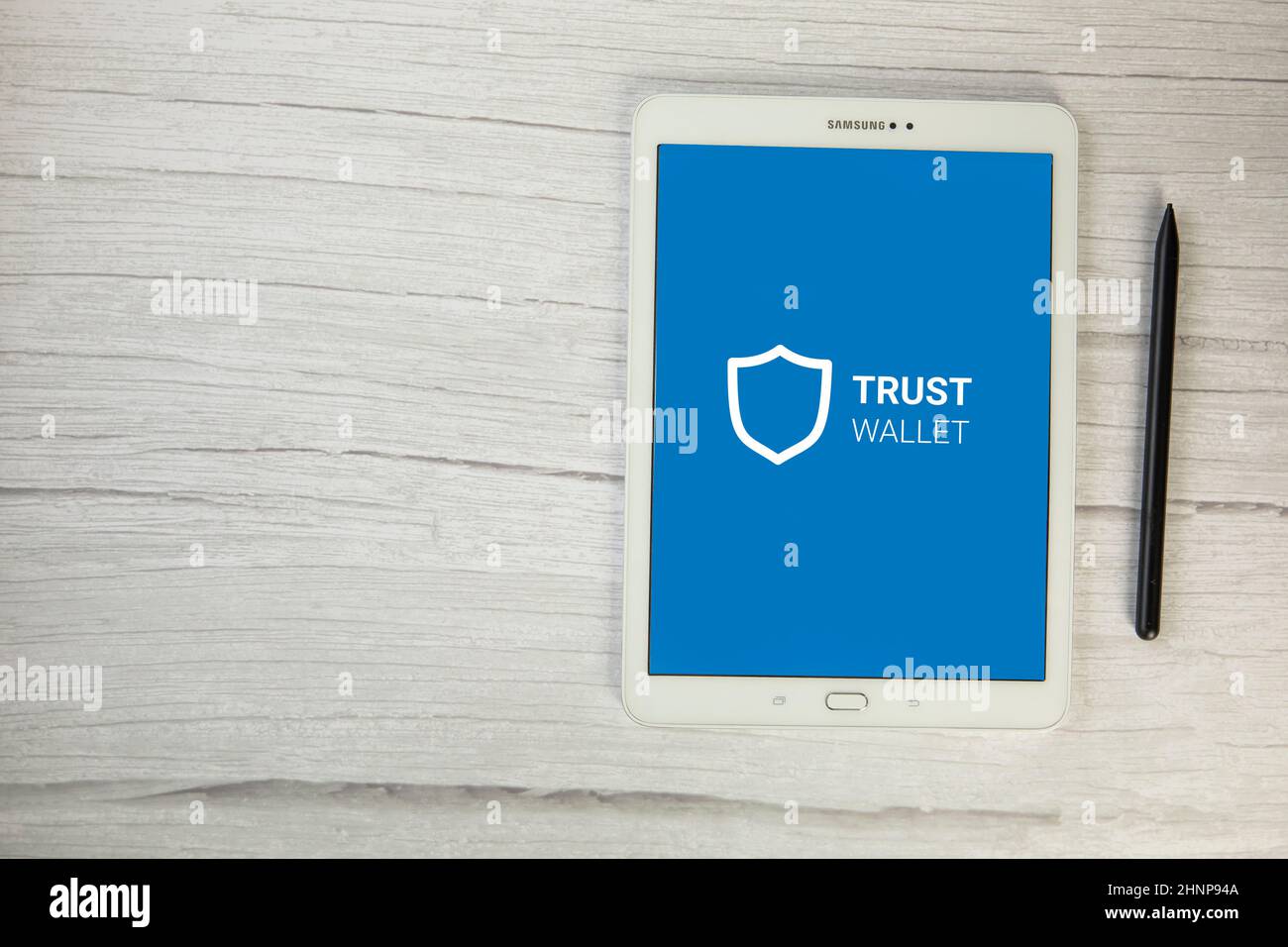 Niederlande, Dezember 2021 Trust Wallet App Crypto Bitcoin eWallet auf digitalem Tablet Draufsicht auf Holztisch, sichere Zahlung für Kryptowährung Stockfoto
