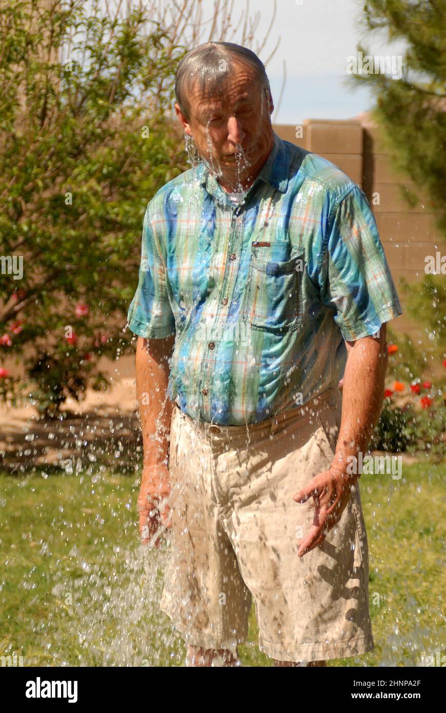 Mann spritzte mit Wasser Stockfoto