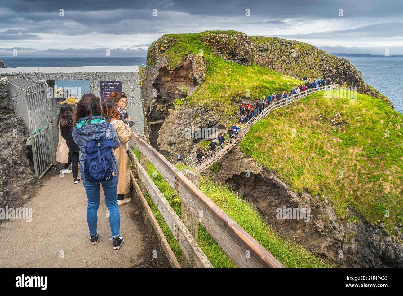 Eine Gruppe von Menschen, die Schlange stehen, um die Seilbrücke Carrick a Rede zu überqueren Stockfoto