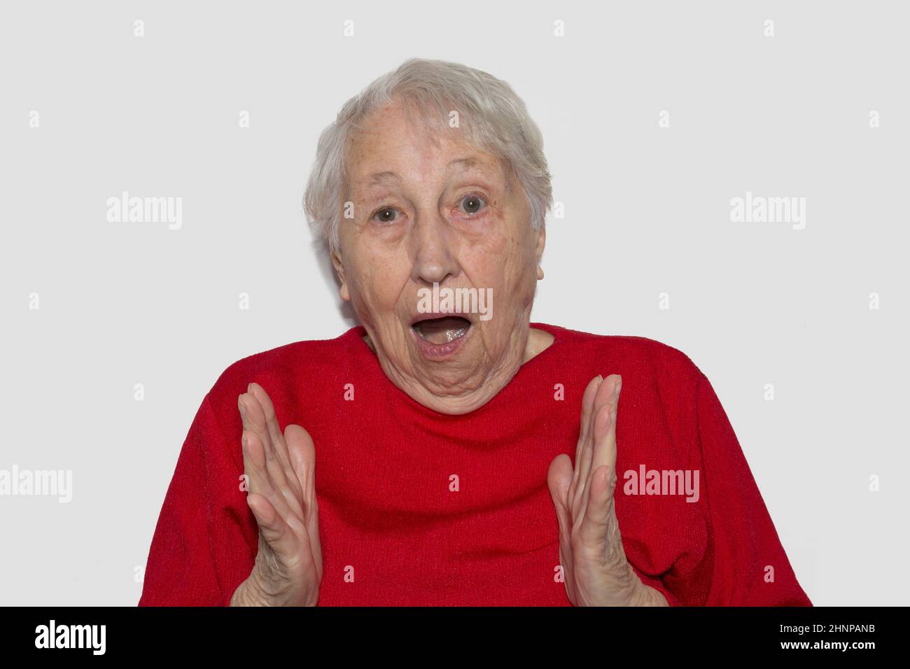 Das Porträt einer überraschten älteren Frau auf weißem Hintergrund Stockfoto