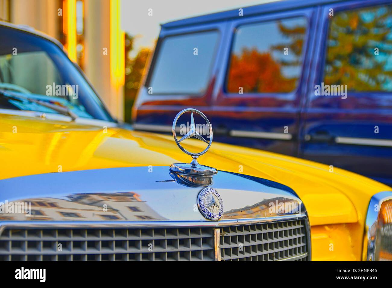 Mercedes Benz Logo auf einem gelben Oldtimer. Mercedes-Benz ist ein deutscher Automobilhersteller. Die Marke wird für Luxusfahrzeuge, Busse, Reisebusse und Lastwagen verwendet. Stockfoto