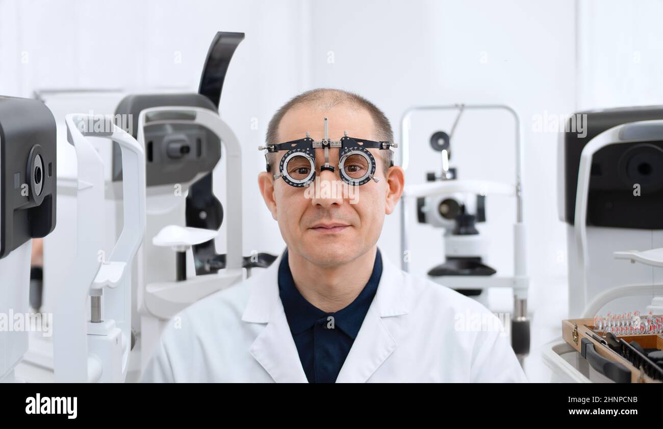 Der Augenarzt ist gerahmte Gläser, um das Augenlicht umgeben von medizinischen Geräten zu überprüfen. Stockfoto