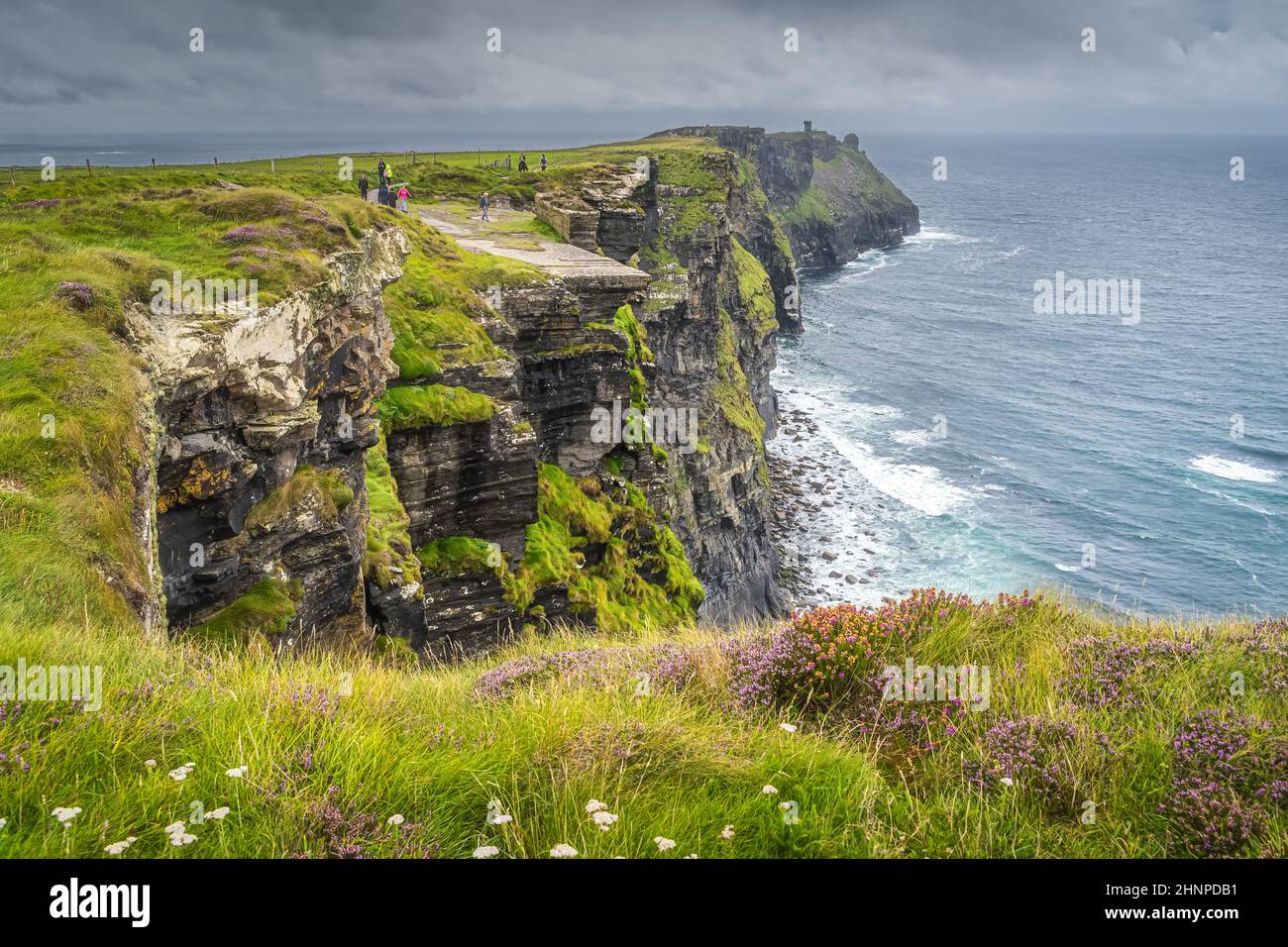 Eine Gruppe von Menschen, die die berühmten Cliffs of Moher, Irland, besichtigen Stockfoto