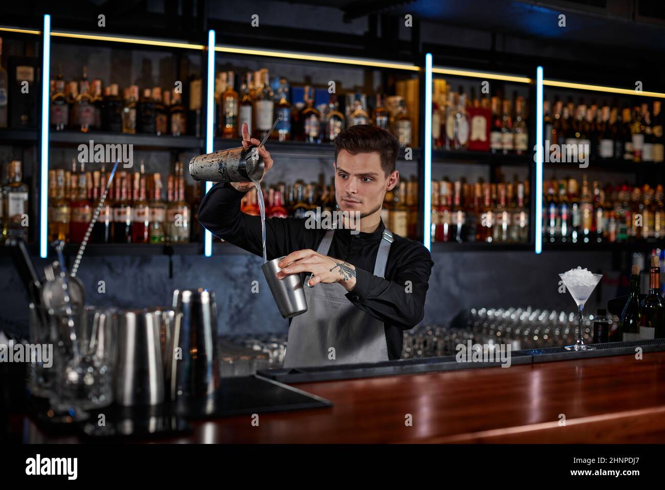 Barkeeper macht Cocktail mit Stahlschüttler Stockfoto