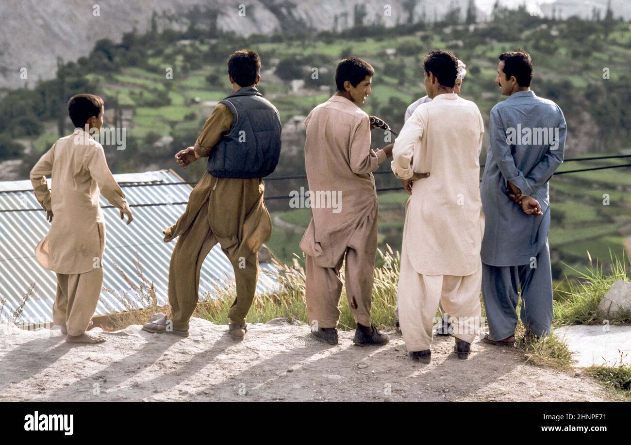 pakistanische Männer am Karakoram Highway in einheimischer Kleidung beobachten das Tal Stockfoto