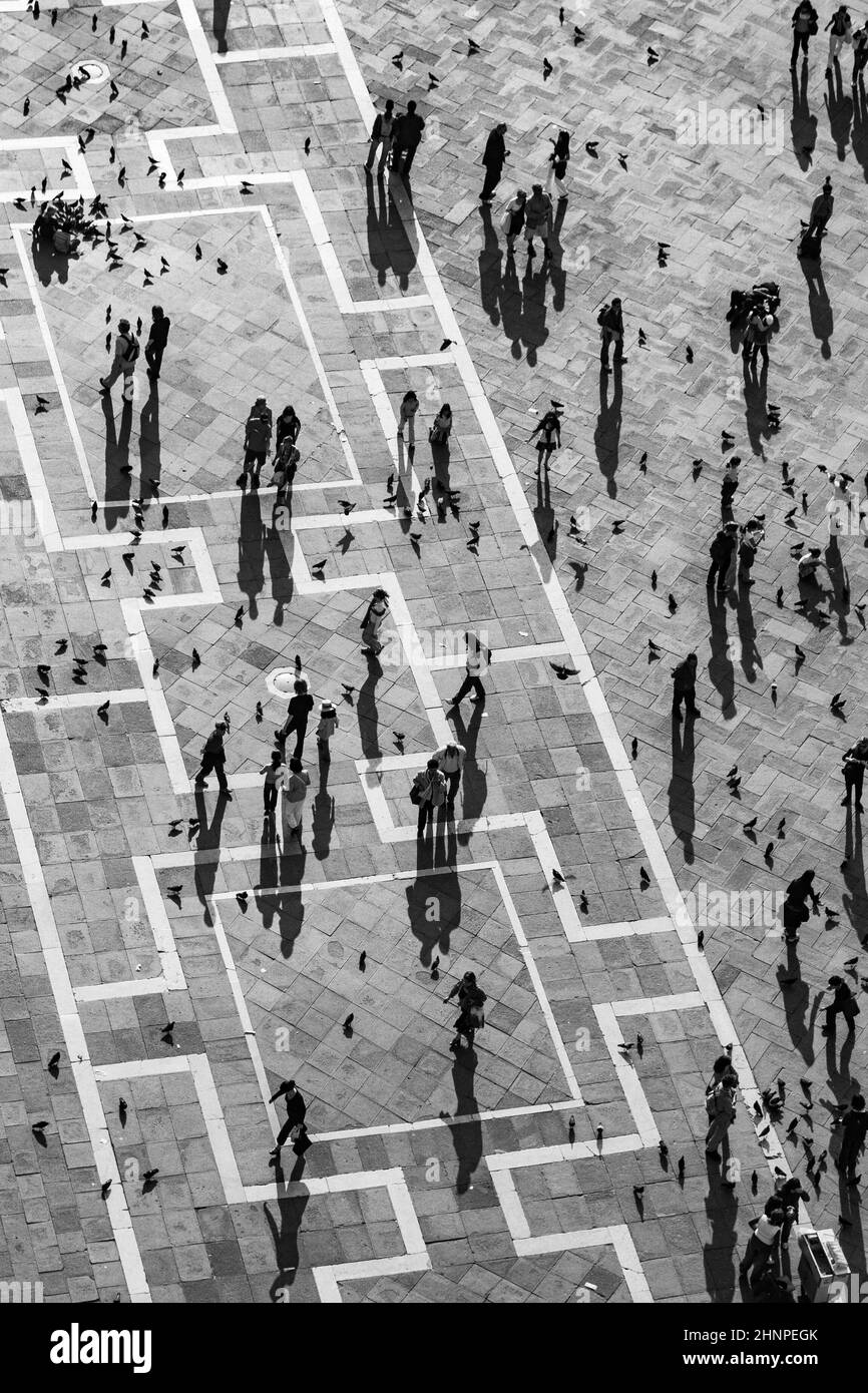 Touristen auf dem Markusplatz füttern eine große Taubenschar Stockfoto