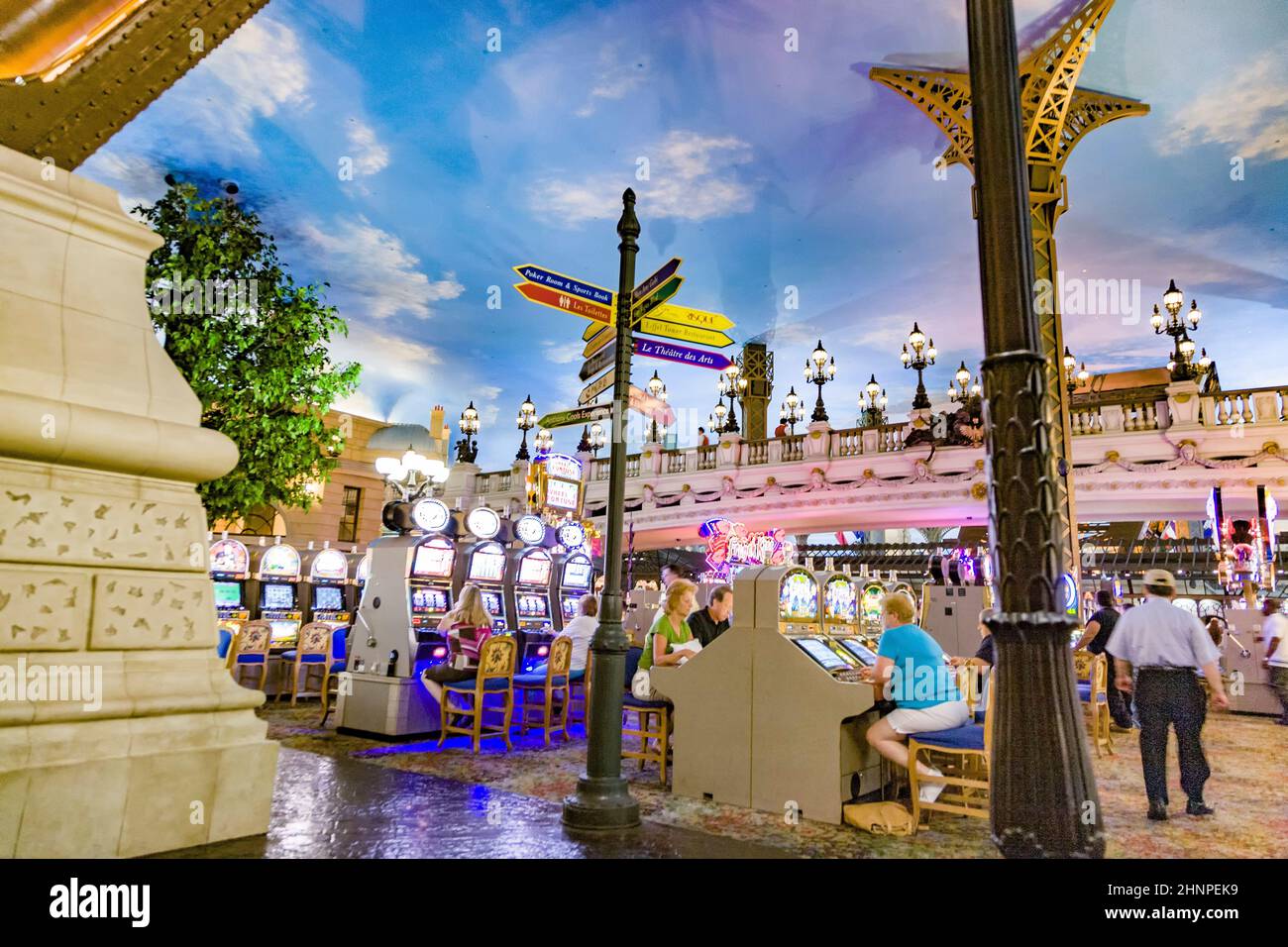 Spieler, die im Casino sitzen und mit Spielautomaten spielen Stockfoto