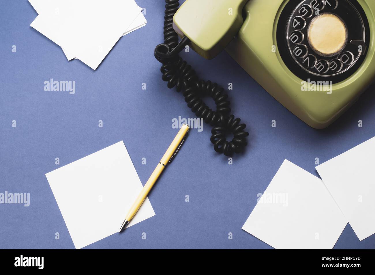 Klassisches Telefon mit Mobilteil. Stift mit Note. Bürohintergrund. Altmodisches Telefon mit Telefonhörer. Alte Kommunikationstechnik. Kopierraum Stockfoto