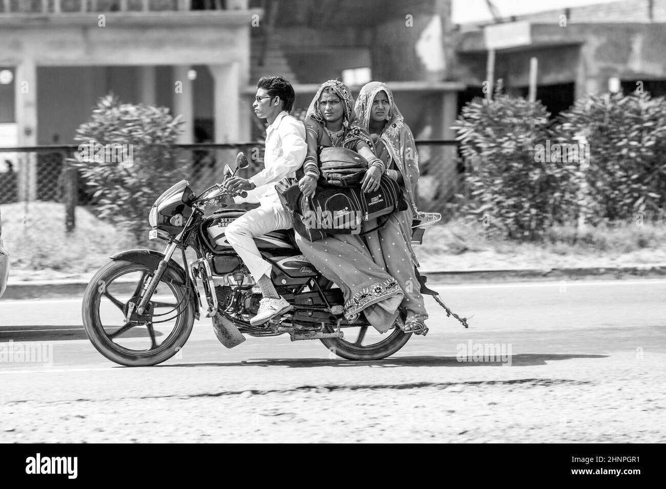Mann mit Mutter und Frau, die auf dem Roller auf der Autobahn fahren Stockfoto